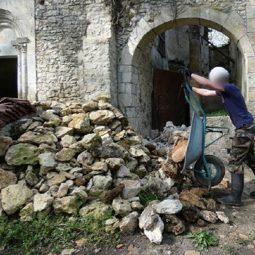 Décharge de pierres avec une brouette par un jeune